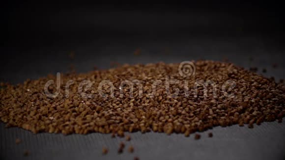 谷物荞麦在黑色背景下缓慢运动视频的预览图