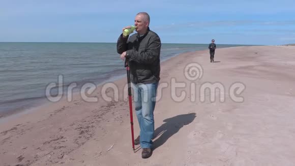 海边海滩上有瓶水的徒步旅行者视频的预览图