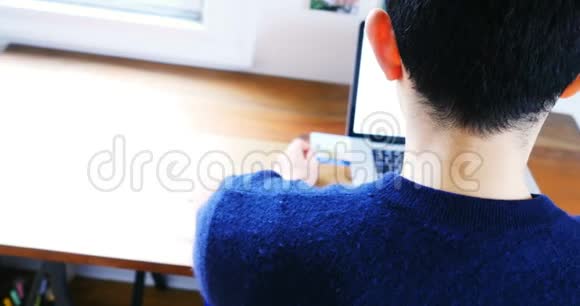 男人在笔记本电脑上做网购视频的预览图