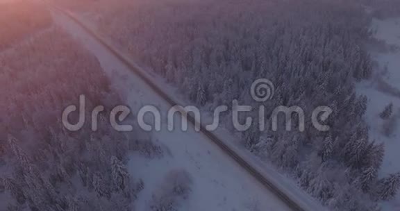 在冬天用一辆汽车俯瞰一片多雪的森林和公路视频的预览图