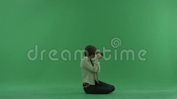 坐着的年轻女子正在右边的绿色屏幕上拍照视频的预览图