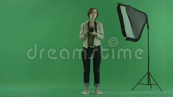 一位年轻女子正在绿色屏幕上为观众拍照视频的预览图