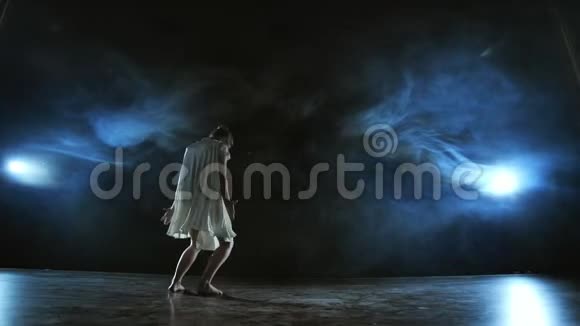 穿着白色裙子的女人在舞台上与烟雾跳舞现代芭蕾视频的预览图