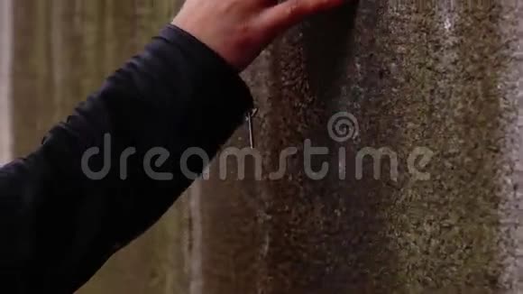 女人用红色的指甲触摸混凝土墙视频的预览图