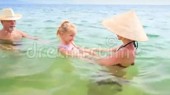 老人母亲托起小女儿在碧海嬉戏视频的预览图