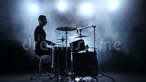 音乐家用棍子在鼓上演奏专业的好音乐烟熏背景剪影视频的预览图