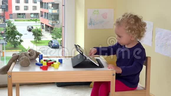 情绪化的孩子使用平板电脑可怜的泰迪熊躺在桌子上视频的预览图