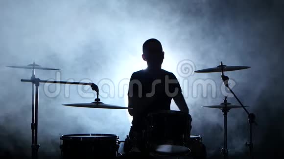 音乐家用棍子在鼓上演奏专业的好音乐烟熏背景剪影视频的预览图