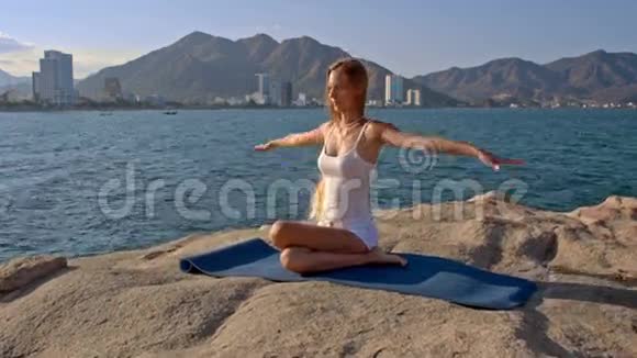 金发女孩坐在莲花瑜伽姿势背后手视频的预览图