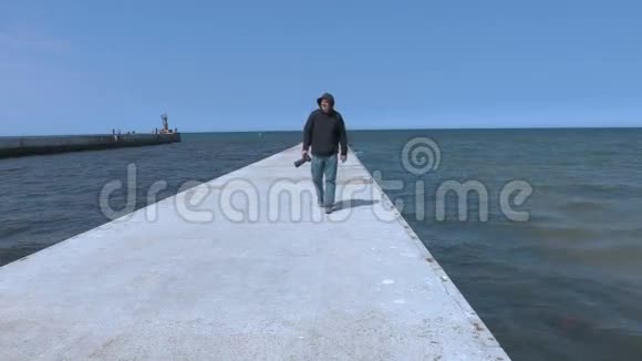 海边码头上的摄影师视频的预览图