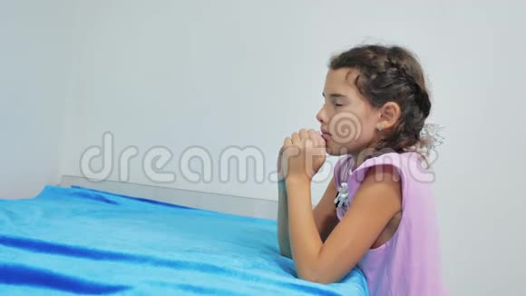 可爱的小女孩在家祈祷小女孩睡前晚上祈祷小女孩和宗教观念视频的预览图