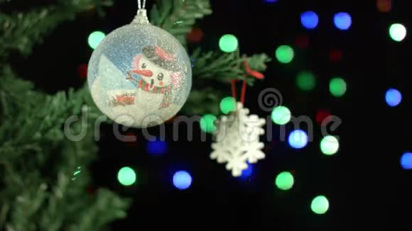 圣诞装饰球和雪地上的背景模糊的灯光花环视频的预览图