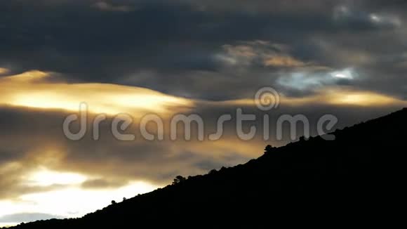 日出时金色的云彩在山上掠过视频的预览图