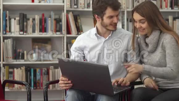 学生们在图书馆用笔记本电脑看东西视频的预览图