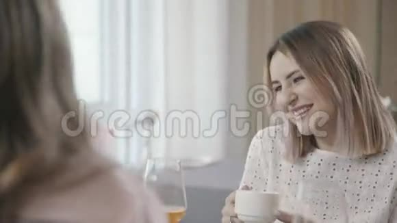 两个相似的女人在咖啡馆里和朋友交流微笑视频的预览图