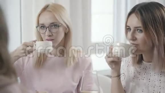 餐馆里的两个女孩喝茶看着对面的对话者视频的预览图