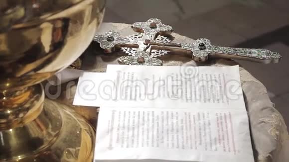 教堂圣经旁边祭坛上的银正体十字架桌子上的谎言特写视频的预览图