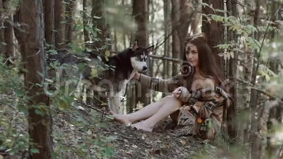 迷人的年轻女子和漂亮的狗坐在野外视频的预览图