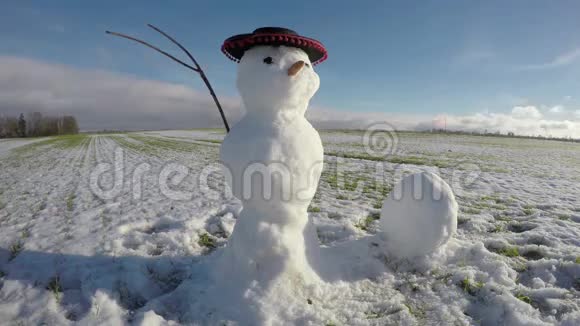 冬季田野上有趣的雪人帽子掉下来时间流逝4K视频的预览图