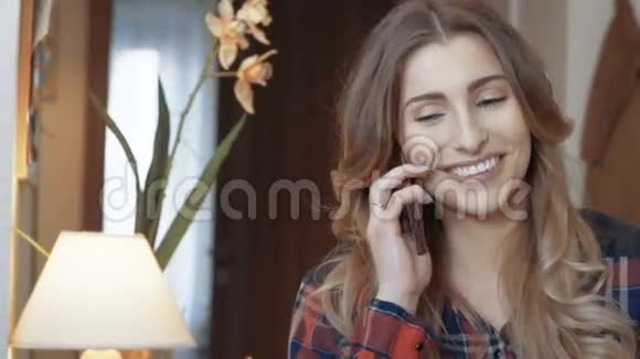 年轻快乐的女人坐在客厅里打电话视频的预览图
