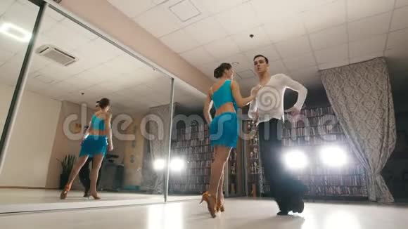 年轻漂亮的男人和女人在工作室里穿着服装跳舞和排练拉丁美洲舞蹈视频的预览图