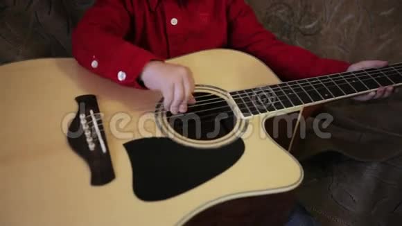 穿红色衬衫弹吉他的小男孩视频的预览图