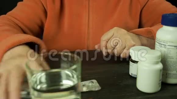 老年妇女手拿药片喝水视频的预览图