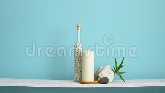 现代客房装饰与框架模型白色架子靠在粉彩绿松石墙上瓶子里有蜡烛和岩石手把手视频的预览图