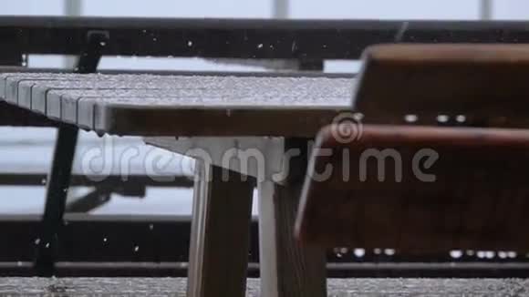 室外桌子和长凳雨和冰雹慢动作视频的预览图
