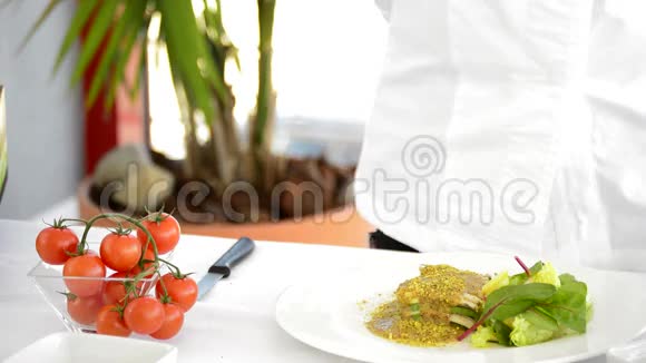 厨师的手切割和在盘子里加入樱桃番茄视频的预览图
