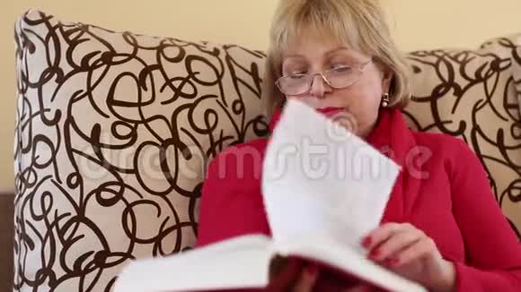 女人坐在沙发上翻翻大书页视频的预览图