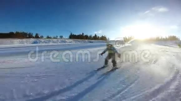 小男孩从雪坡滑过高山滑雪板视频的预览图