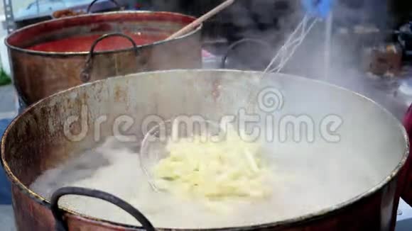 油中的土豆薯条有害脂肪食品街头食品脂肪油缸中的土豆烹饪视频的预览图
