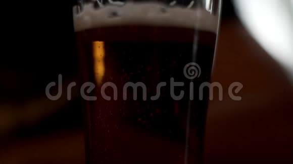 酒吧酒吧桌上的啤酒杯有泡沫啤酒和气泡的玻璃杯视频的预览图