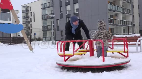 快乐的家庭男人和女孩在冬天的操场上旋转圆圈4K视频的预览图
