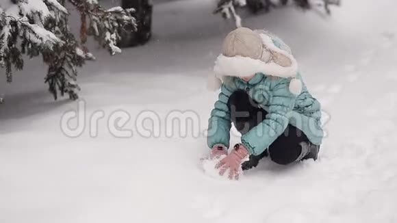 冬天公园里的小女孩雕刻雪人从天而降的雪视频的预览图