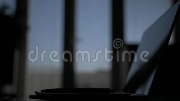 女性深夜用记事本在窗口背景下从笔记本电脑上写文字视频的预览图