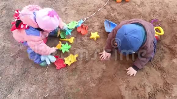 快乐的小女孩和男孩在沙滩上玩塑料玩具视频的预览图