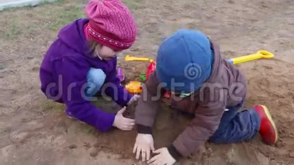 快乐的小女孩和男孩在沙滩户外玩塑料玩具视频的预览图