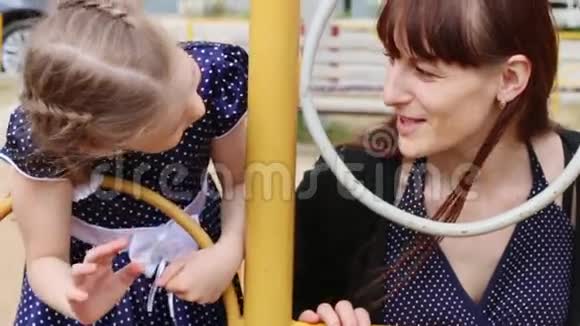 小女孩和她的母亲在夏天玩儿童游乐场视频的预览图