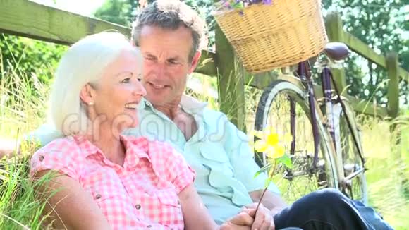 中老年夫妇在乡村骑行中放松身心视频的预览图