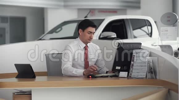汽车推销员坐在陈列室里视频的预览图