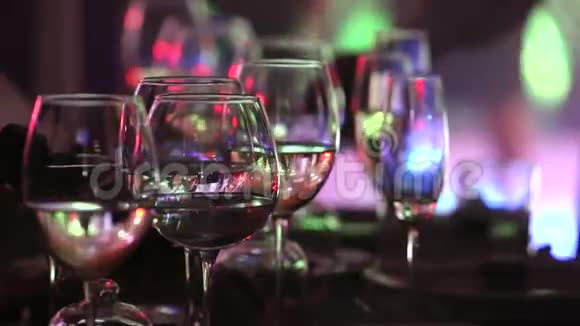 餐厅桌子上的玻璃眼镜舞台灯光背景深色浅景特写视频的预览图