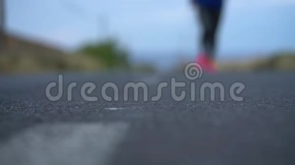 跑鞋在山区的沙漠道路上系鞋带的女人慢动作视频的预览图