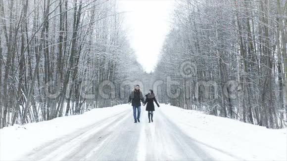 女孩和男孩沿着马路走进树林握着手他们接吻视频的预览图