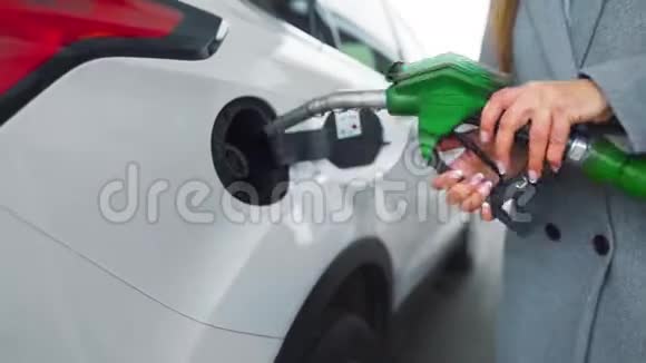 在加油站的一个特写镜头里女人往她的车里灌汽油视频的预览图