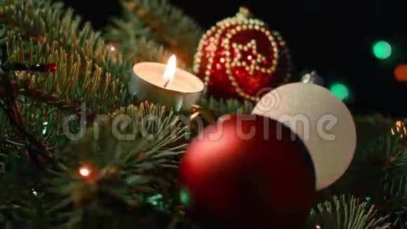 美丽的圣诞树在模糊的灯光花环的背景上有球和蜡烛视频的预览图