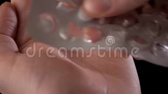 把男人的手伸出来从黑色的水泡里取出药丸视频的预览图