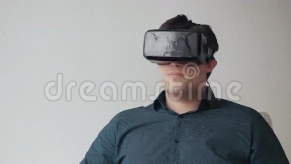 使用虚拟现实眼镜的人专用耳机隔离在白色的地面上视频的预览图