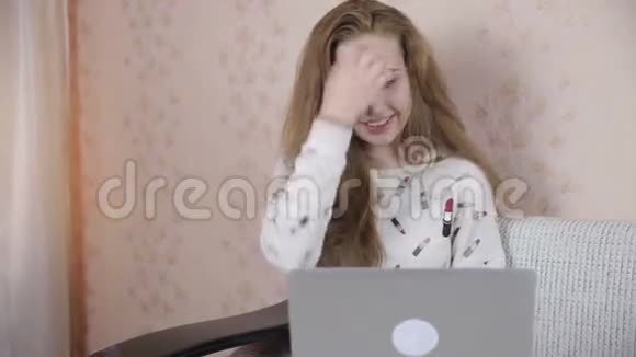 微笑英俊可爱的女孩使用笔记本电脑视频的预览图